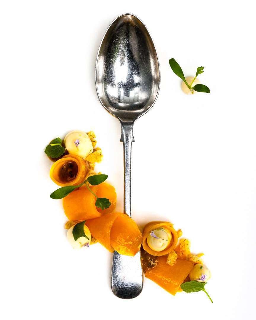 Spoonfuls of Inspiration: Ashley Brauze - Culinary Artistry Spoonful portrait of Pastry Chef Ashley Brauze featuring champagne mangoes, ginger custard, and micro cilantro with a gifted Oneida print spoon.